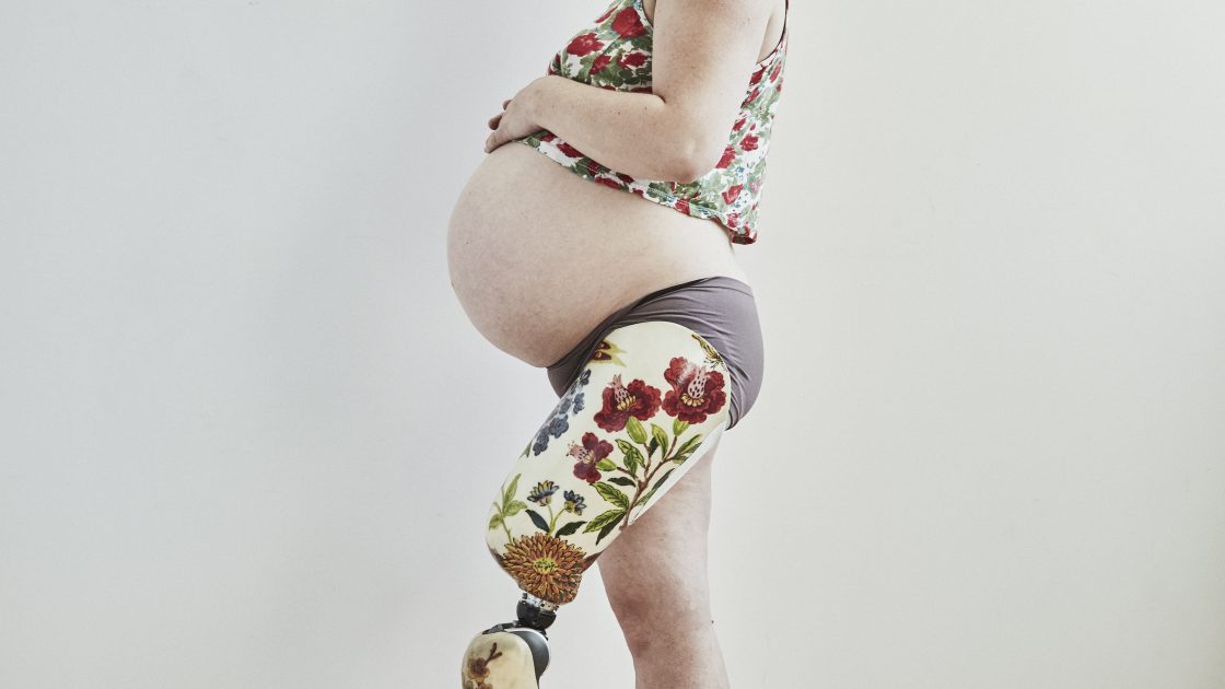 A side shot of a pregnant woman, Christa Couture, wearing a prosthetic leg.